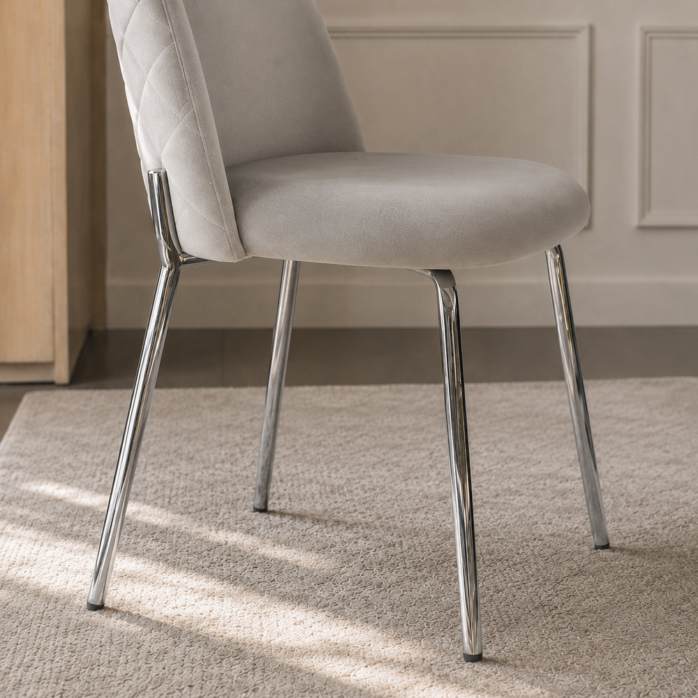 Detalle de las patas metálicas cromadas y el asiento tapizado en pana gris de la silla Catania.