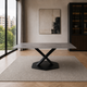 Mesa Cross con tapa rectangular de mármol italiano gris y base metálica negra en forma de X sobre alfombra.