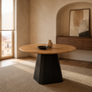 Mesa Concud redonda con tapa símil madera y base metálica negra en un ambiente de comedor.