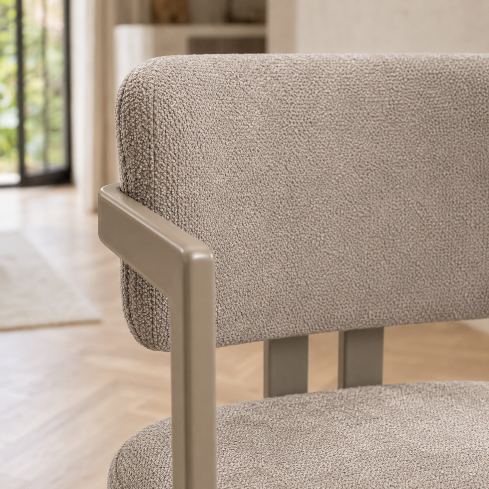 Detalle del tapizado en chenille gris claro y apoyabrazos de la silla Besaya base capuccino.