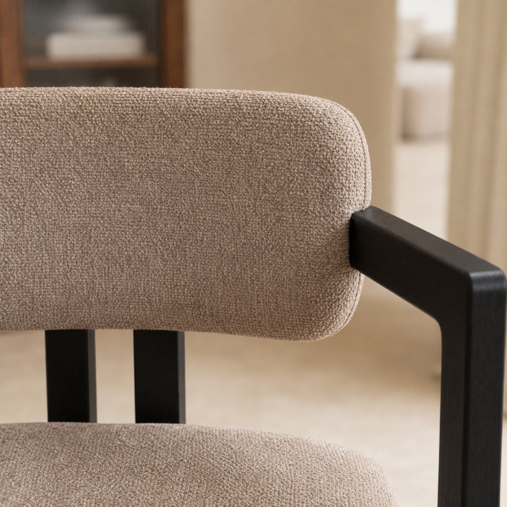 Primer plano de la textura del tejido chenille taupe en el respaldo curvo de la silla Besaya.