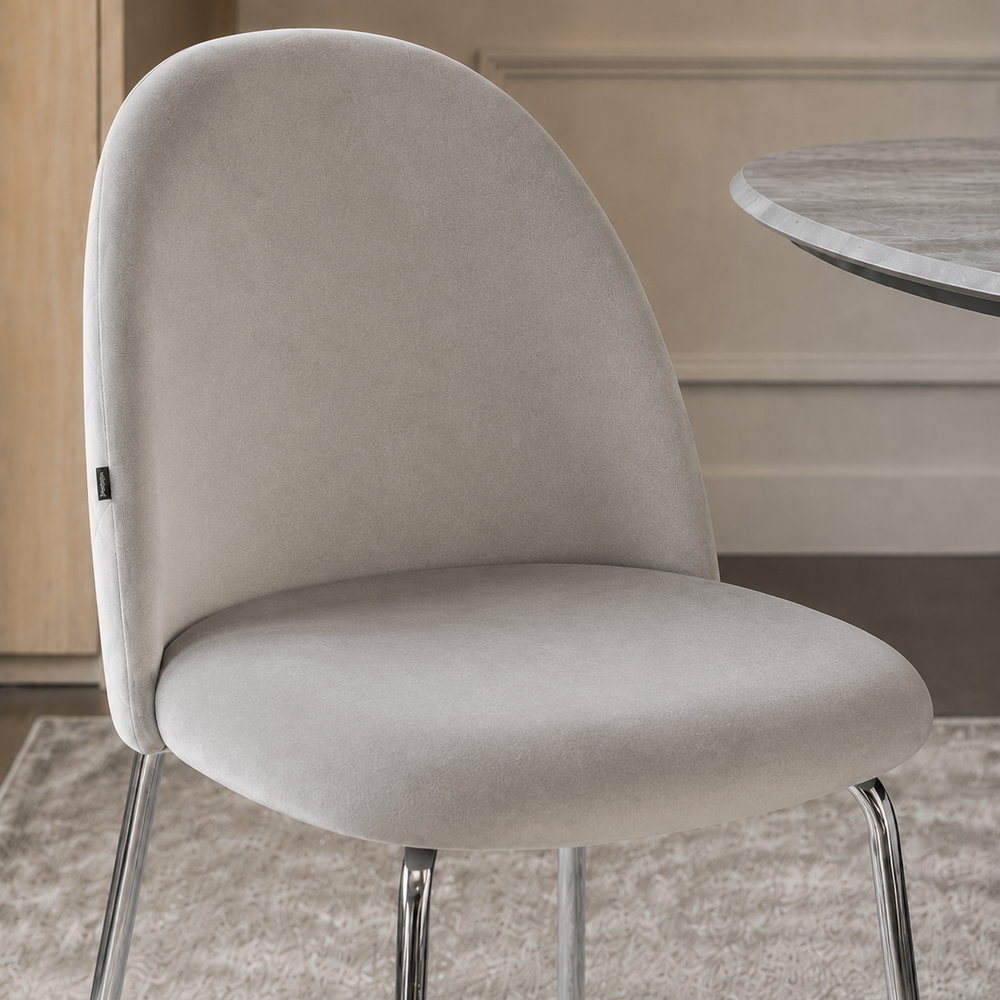 Primer plano del respaldo y asiento de la silla Catania tapizada en pana gris claro.