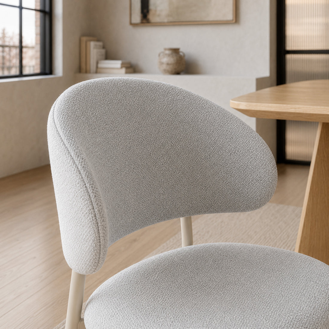 Primer plano del tapizado en chenille gris claro de la silla Pragal, mostrando la textura del tejido.