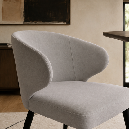 Detalle del respaldo envolvente de la silla Vita en chenille gris claro y textura suave.