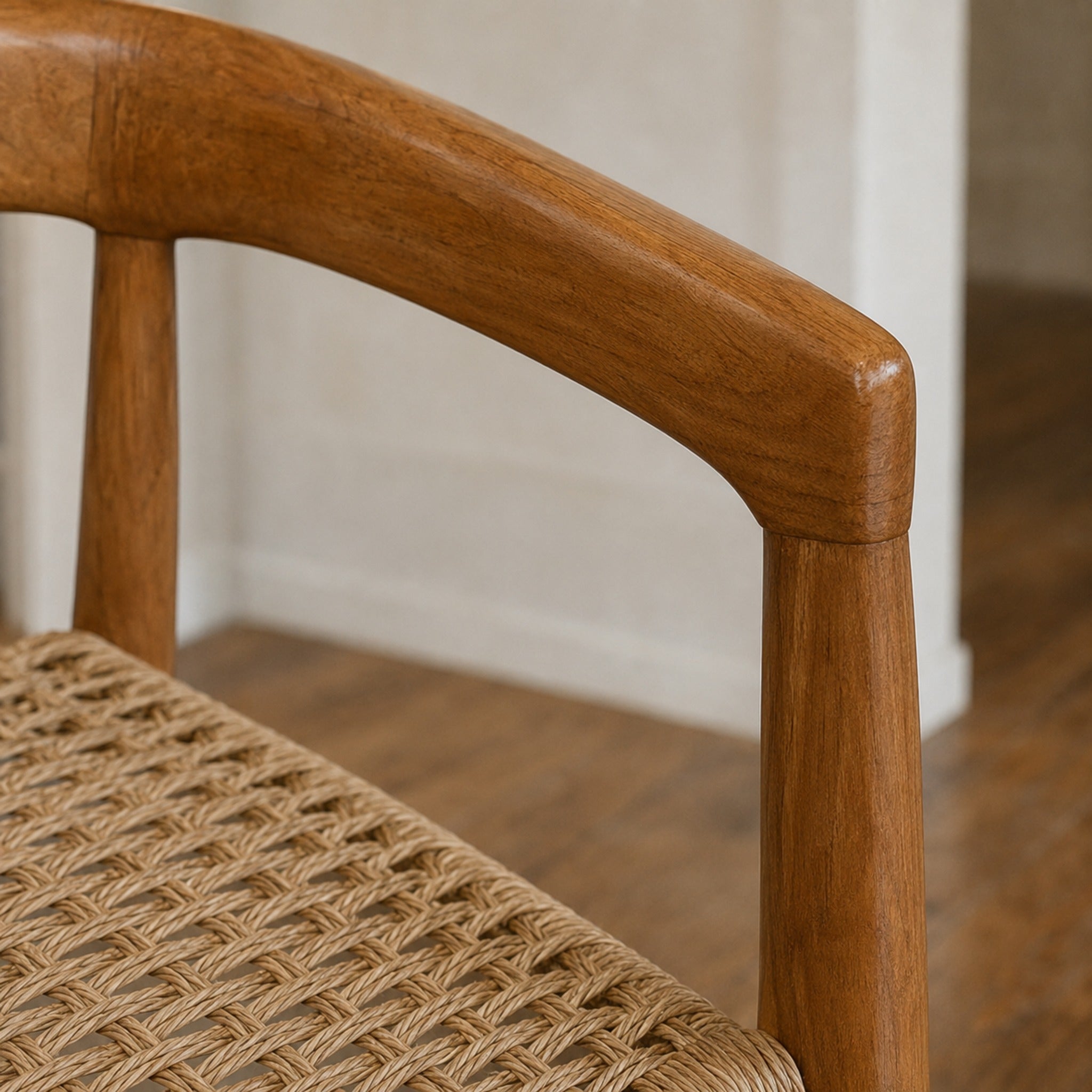 Primer plano del apoyabrazos de madera de teka y el detalle del tramado de kraft laqueado del Sillón Praga.