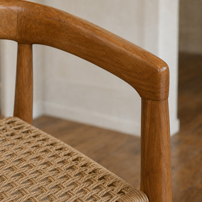 Primer plano del apoyabrazos de madera de teka y el detalle del tramado de kraft laqueado del Sillón Praga.