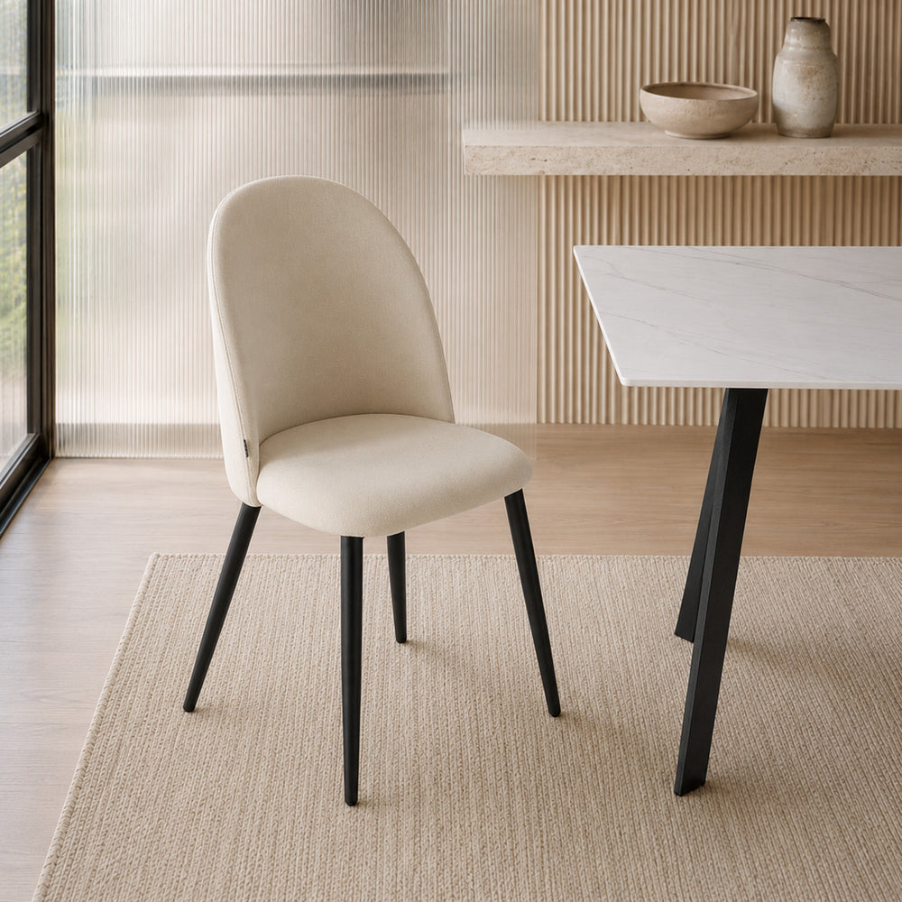 Silla Livia Lisa beige con base metálica negra, vista frontal completa en ambiente de diseño neutro.