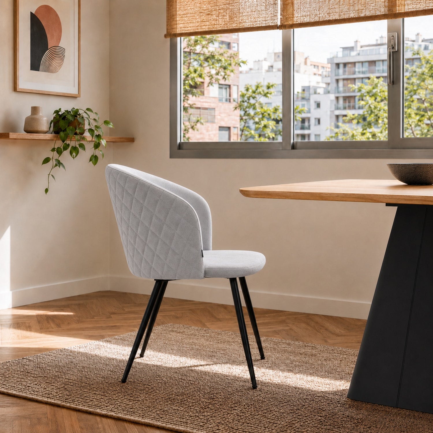 Vista de perfil de la silla Jade en pana gris claro, resaltando la curvatura del asiento y sus patas negras delgadas.