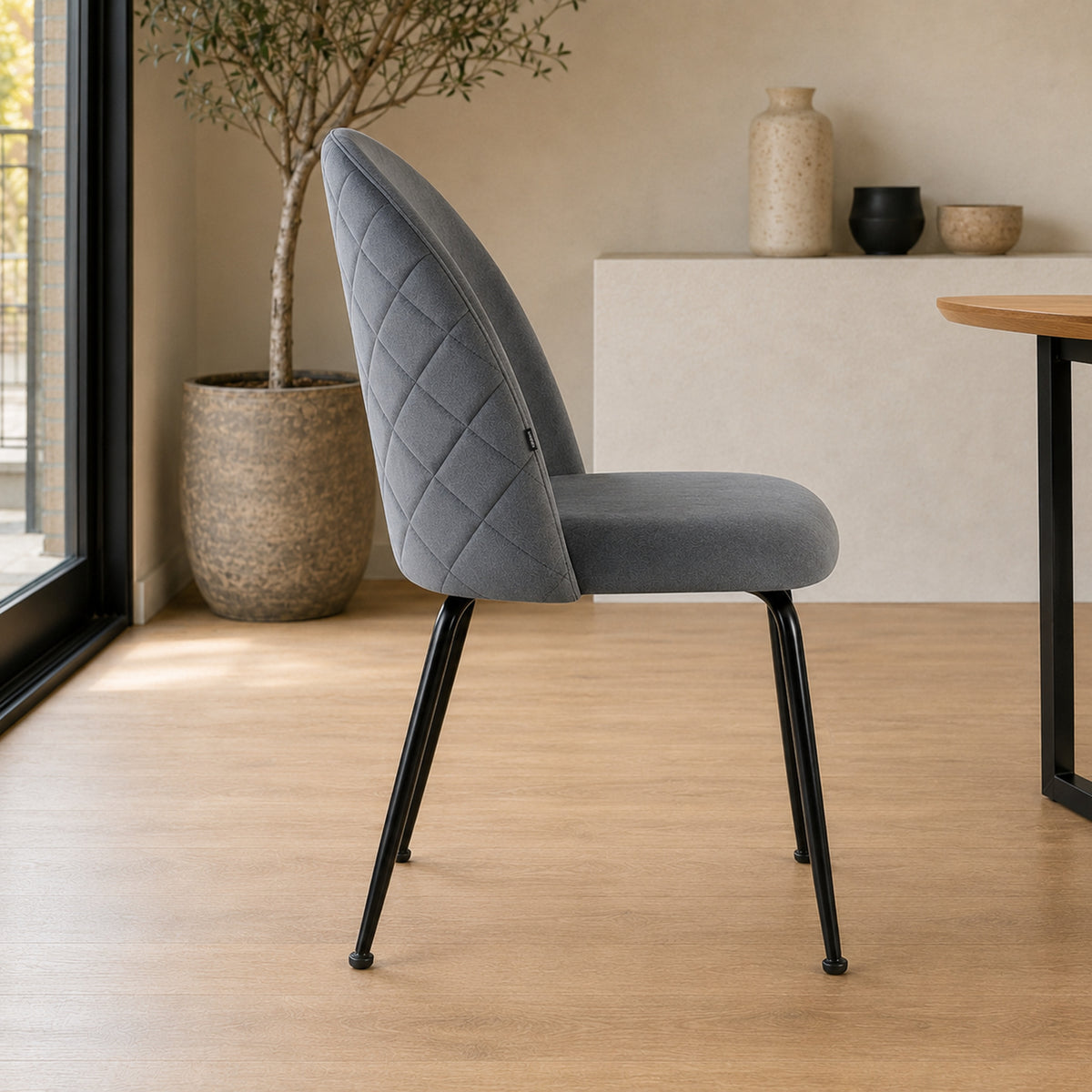 Perfil de la silla Venecia destacando la curvatura del respaldo y el diseño matelassé lateral.