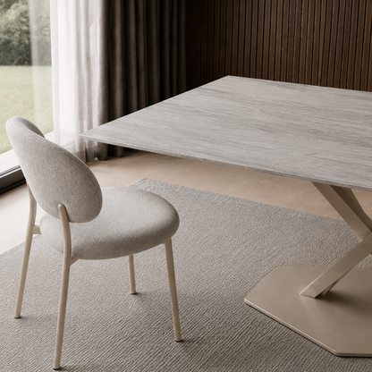 Primer plano de una silla junto a la esquina de la mesa Cross con terminación travertino.