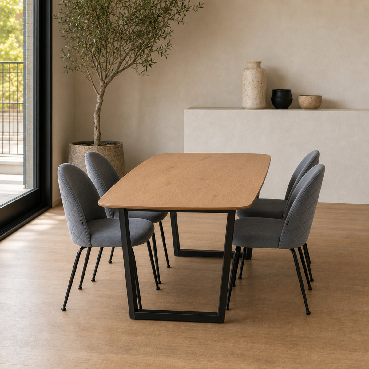 Cuatro sillas Venecia grises dispuestas alrededor de una mesa de comedor de madera con base negra.