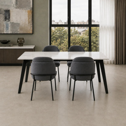 Cuatro sillas Katia gris oscuro dispuestas alrededor de una mesa de comedor con tapa de mármol blanco.