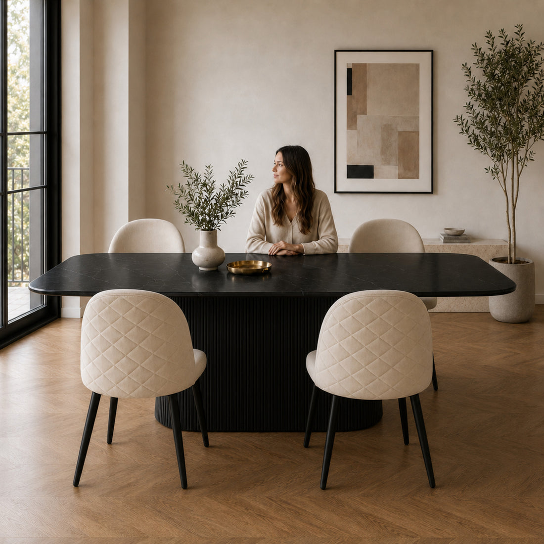 Juego de comedor ambientado con sillas Livia Matelassé beige y mesa negra en un entorno luminoso.