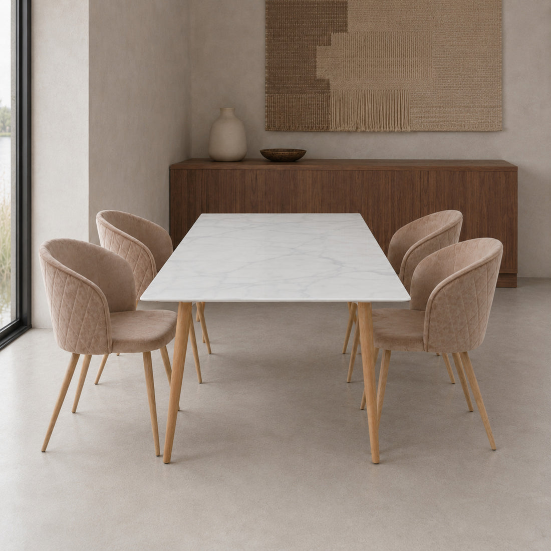 Cuatro sillas Jade en pana taupe dispuestas en un comedor junto a una mesa blanca de estilo mármol.