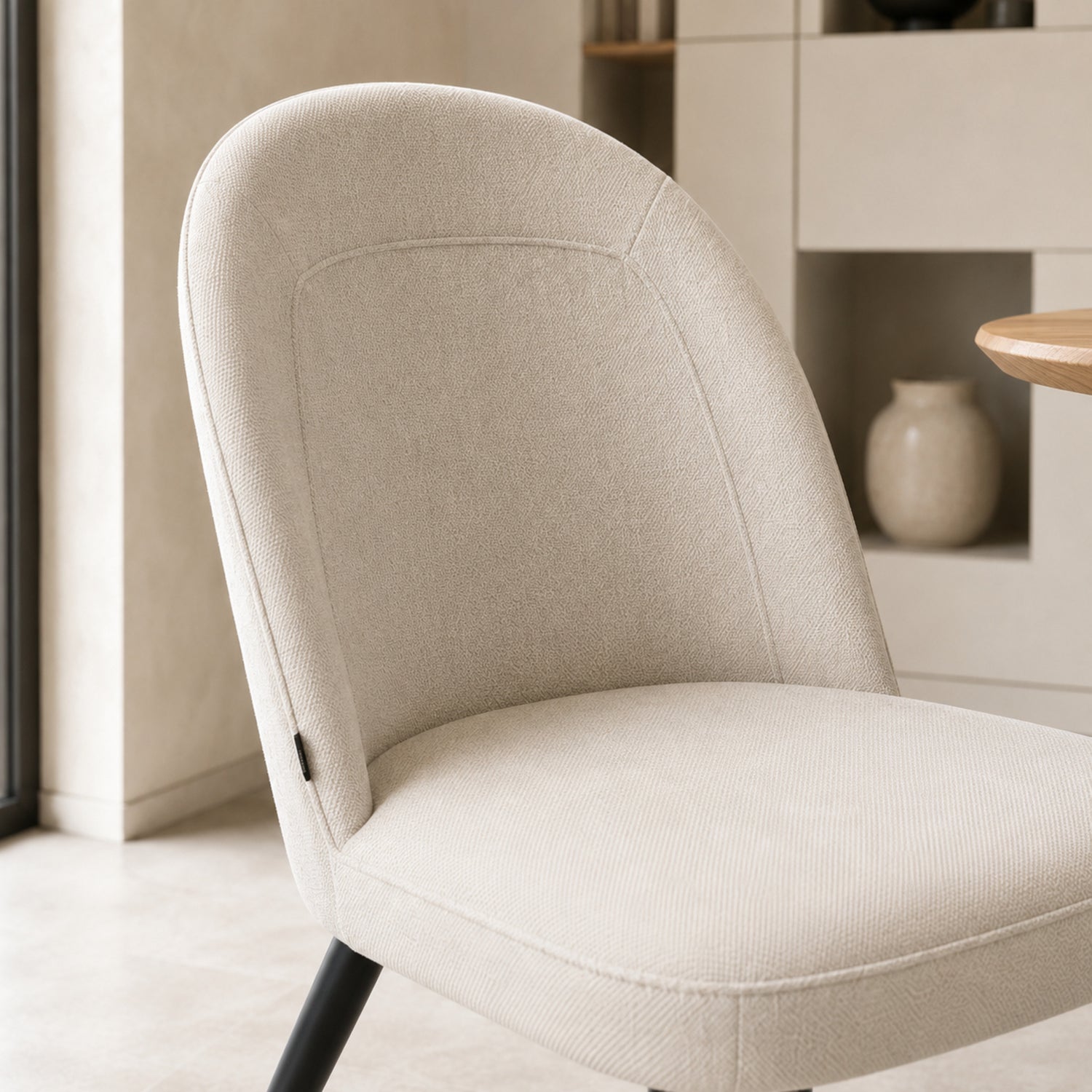 Primer plano del respaldo de la silla Lara que muestra la textura suave del tapizado en chenille beige.