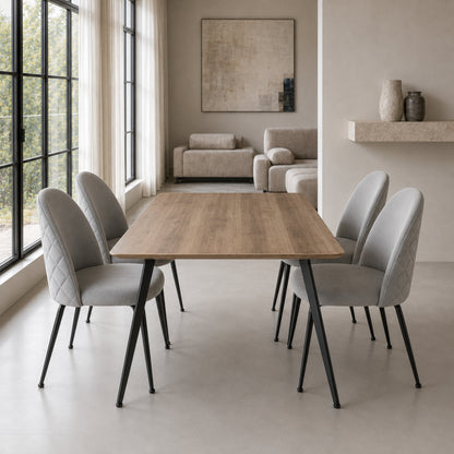 Cuatro sillas Venecia Matelassé color gris claro dispuestas alrededor de una mesa de comedor rectangular.