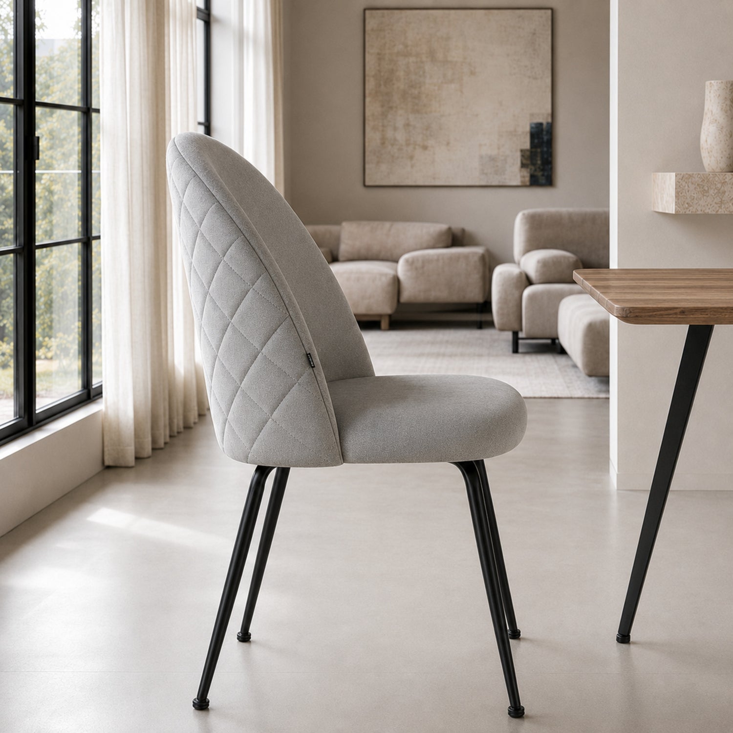 Perfil de la silla Venecia Matelassé en pana gris claro, mostrando la curvatura del respaldo y la estructura negra.