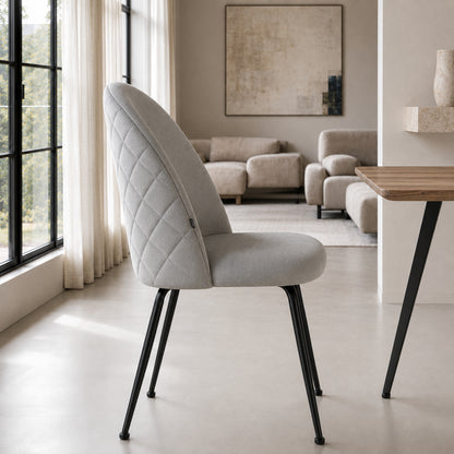 Perfil de la silla Venecia Matelassé en pana gris claro, mostrando la curvatura del respaldo y la estructura negra.