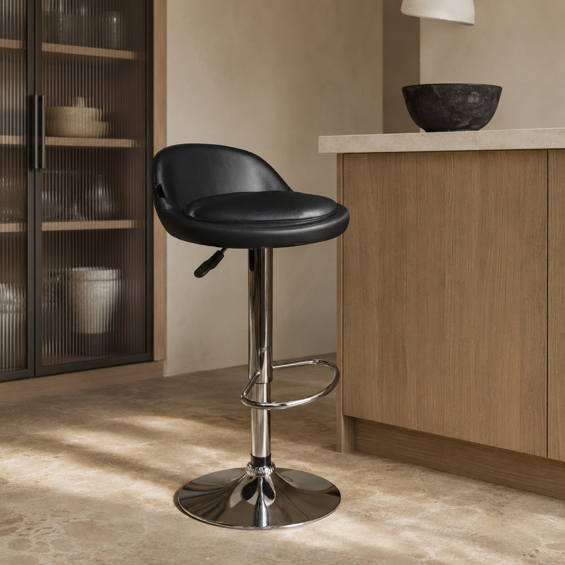 Banqueta Rava de ecocuero negro con base de cromo en una cocina, vista de tres cuartos.