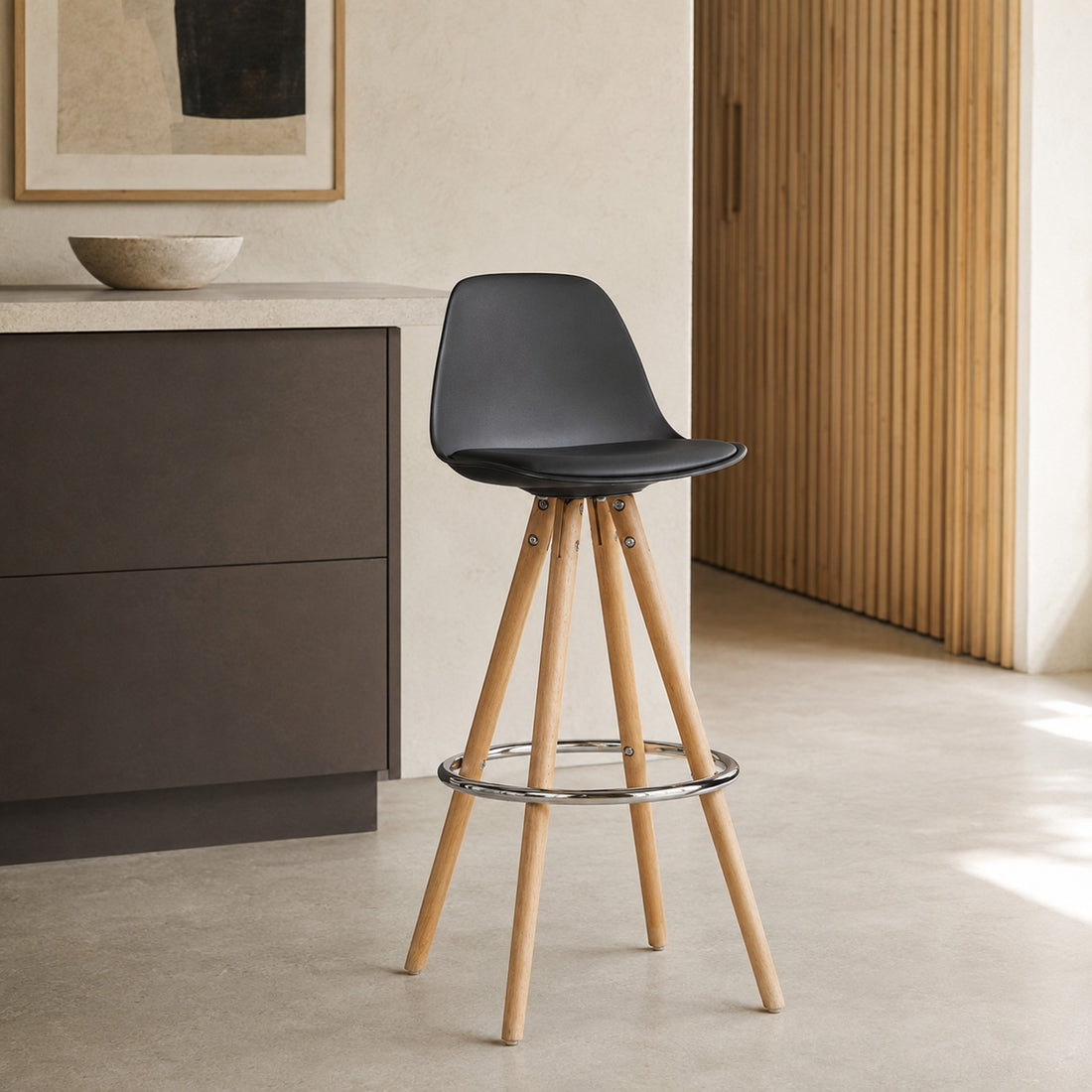 Banqueta Elba negra con asiento de polipropileno, almohadón de eco cuero y patas de madera en perspectiva.