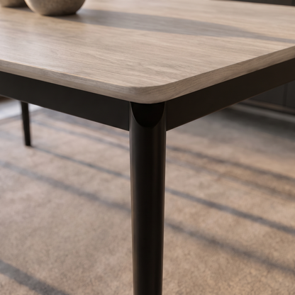 Detalle del canto redondeado de la tapa y la estructura negra de la Mesa Lucca.
