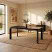 Mesa Ravello Negra con tapa rectangular de piedra y base negra en un comedor.