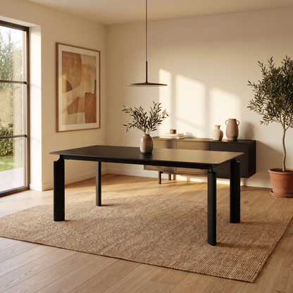 Mesa Ravello Negra con tapa rectangular de piedra y base negra en un comedor.