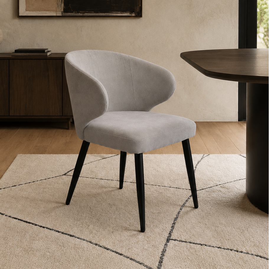 Silla Vita tapizada en chenille gris claro con base metálica negra en un ambiente de comedor.