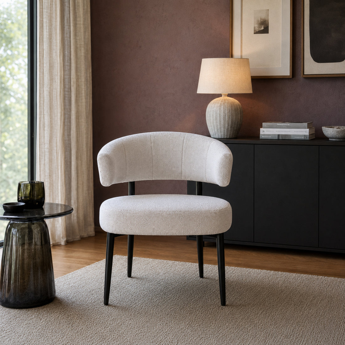 Vista frontal del Sillón Bondie en chenille beige y patas negras, destacando su silueta contemporánea.