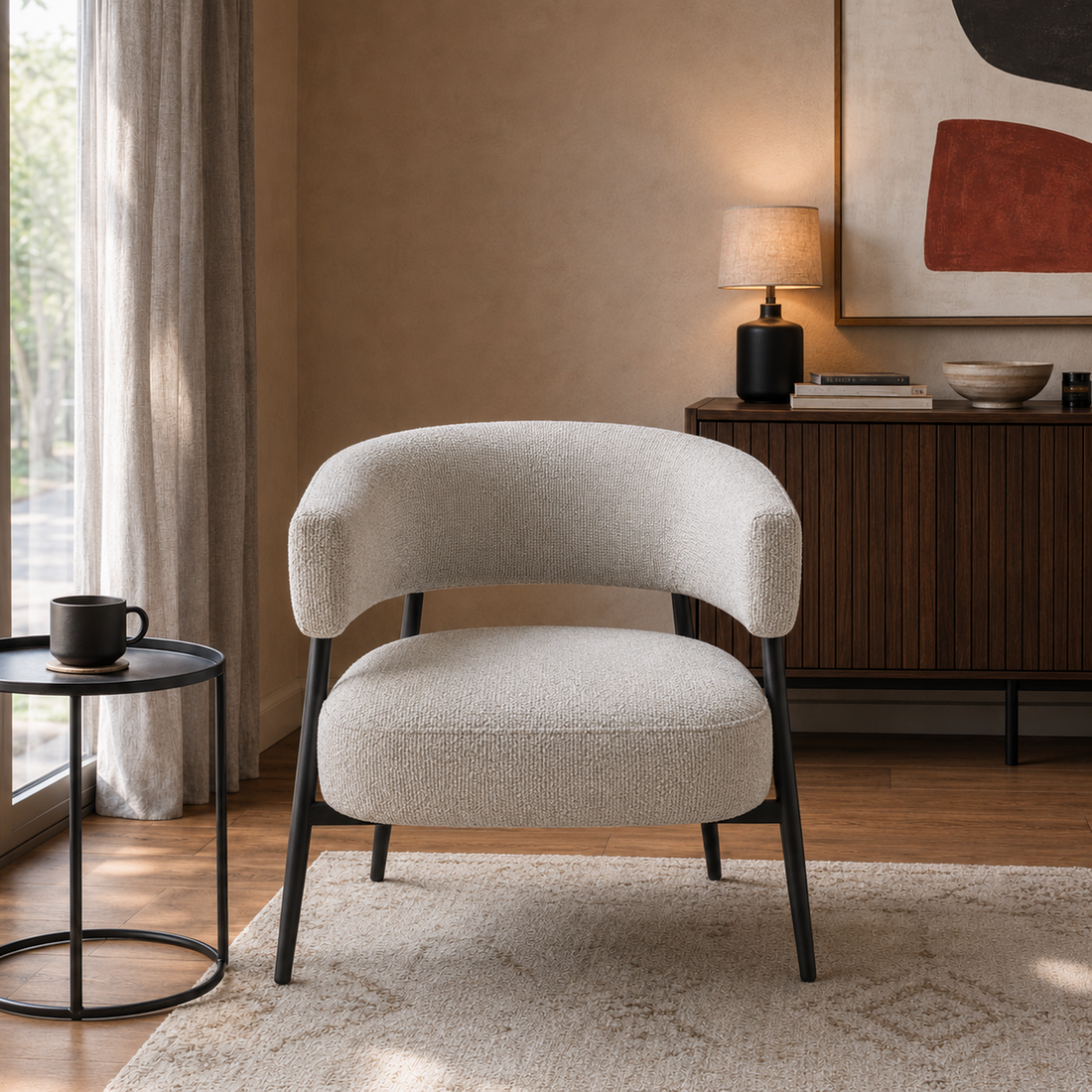 Sillón Dott tapizado en chenille gris y patas negras, vista frontal que muestra el diseño del asiento y respaldo curvo.