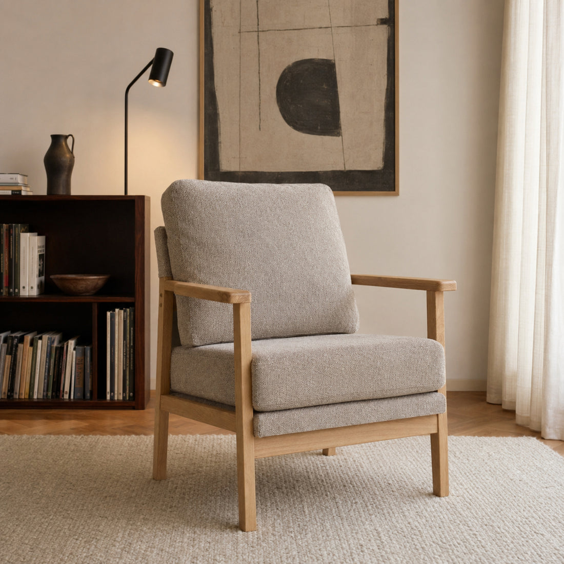 Sillón Niko tapizado en chenille taupe con base de madera natural, visto en ángulo en un living.