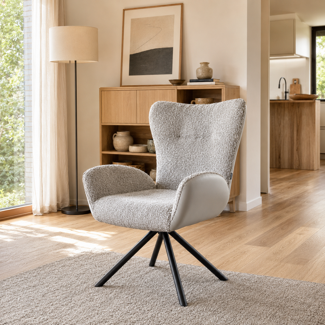 Sillón Niva en gris claro con tapizado combinado de bouclé y ecocuero, vista en ángulo en un living.