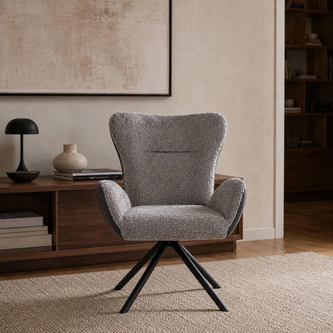 Vista frontal del Sillón Niva destacando el tapizado en boucle gris oscuro y sus cuatro patas metálicas negras.