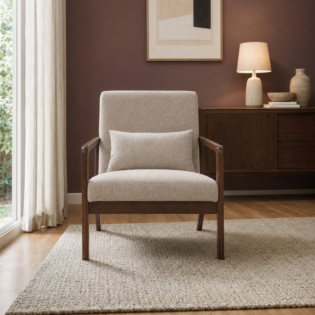 Sillón Riga tapizado en chenille color taupe y estructura de madera oscura, vista frontal en ambiente social.